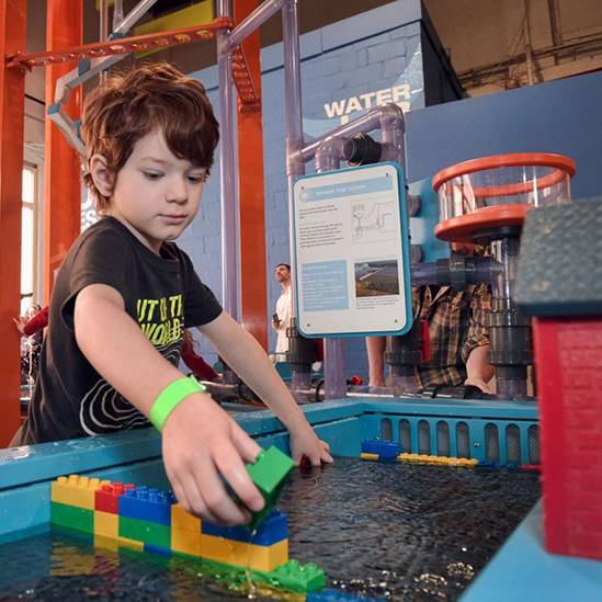 child playing at a water play table